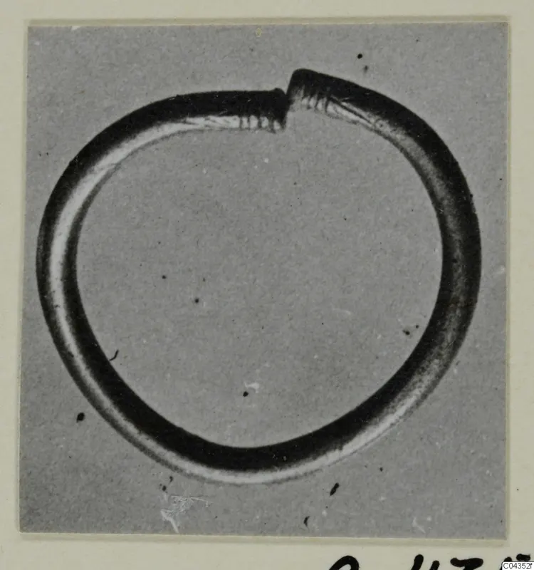 Open silver circlet with its two ends overlapping at the top, photographed against a grey background