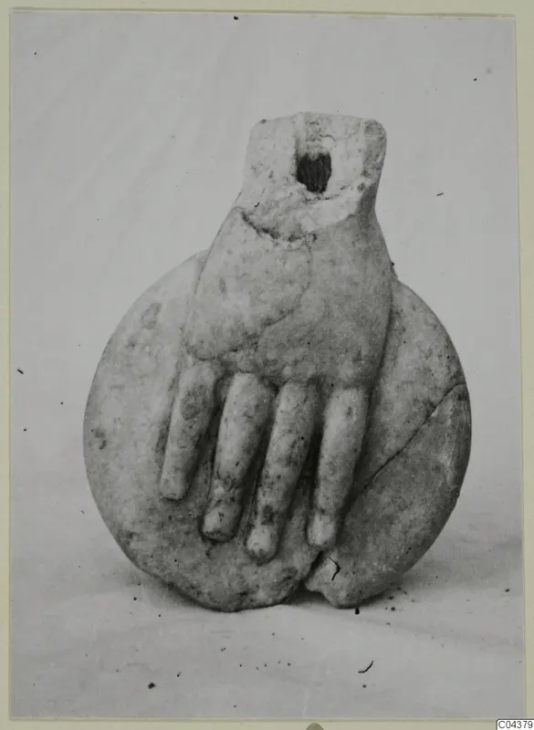 Marble sculpture fragment of a hand with curled fingers resting on a round disc-shaped piece