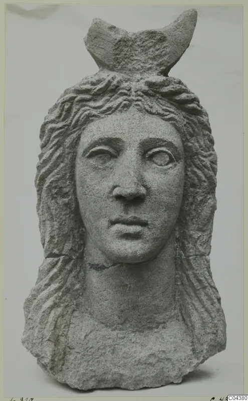 Carved grey stone head and upper bust from Soli, with wavy hair and a crescent-shaped element on the crown.