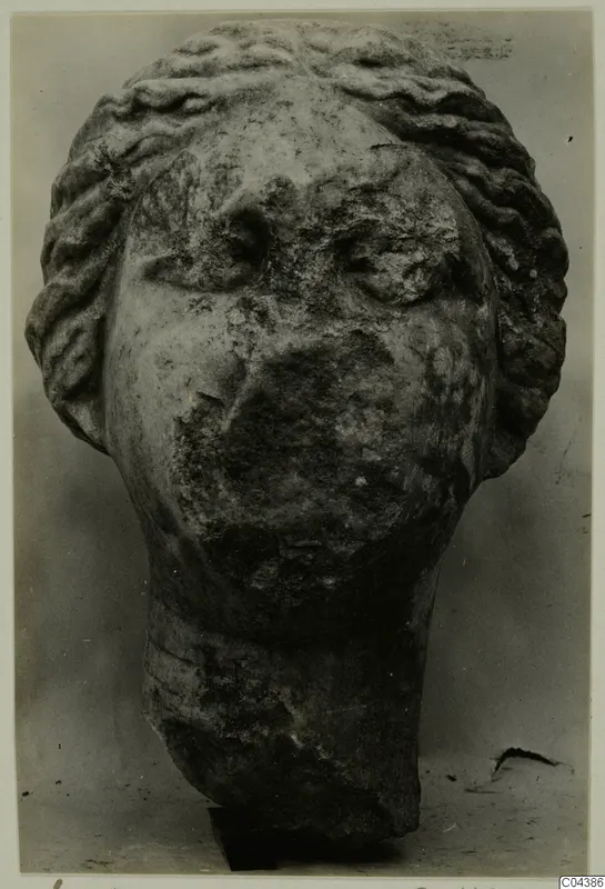 Marble sculpture head from Soli with wavy hair bands and a weathered face