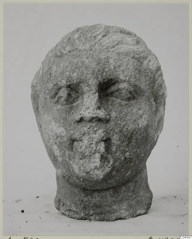 Stone head sculpture from Soli, shown front-on against a plain background.