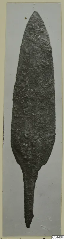 Corroded metal blade, leaf-shaped with a narrow tang, from Ayia Irini