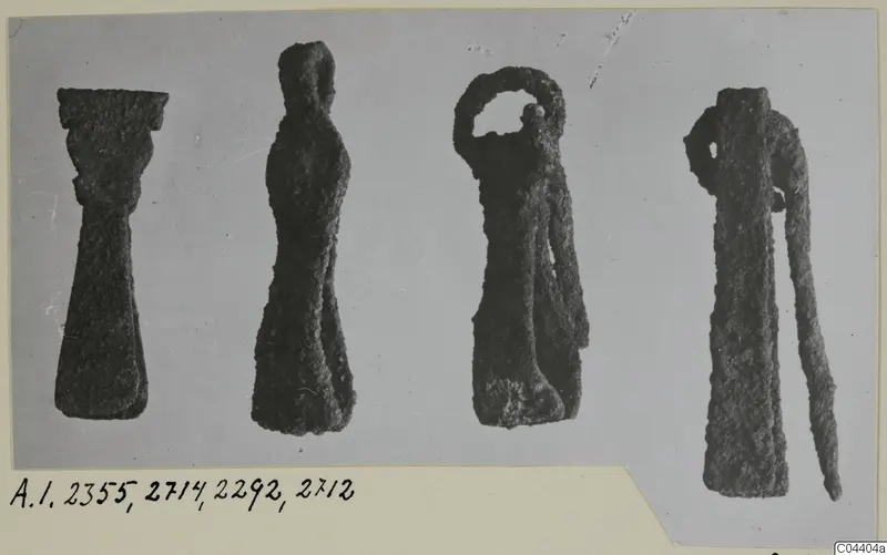 Four corroded bronze toilet-requisites from Amathus tombs, shown side by side on a mounted card