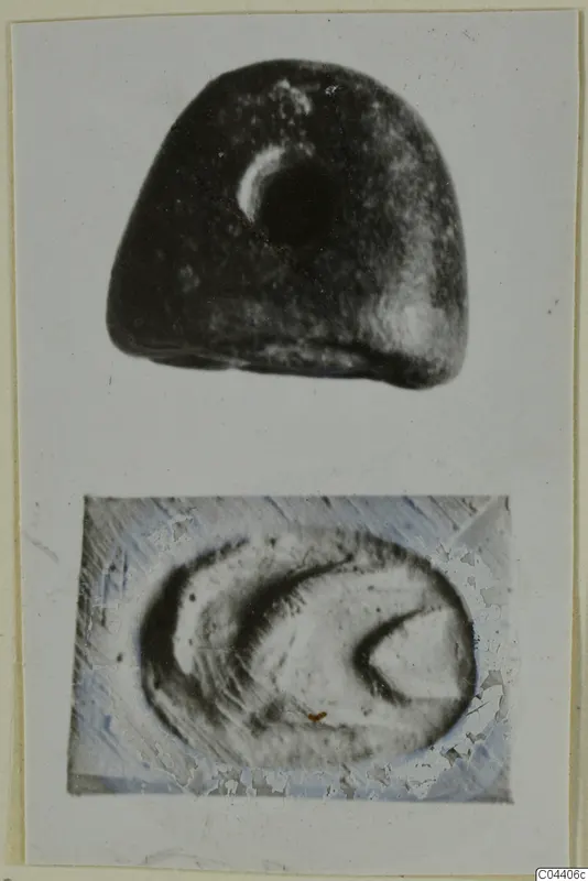 Dark stone seal with a pale crescent mark, shown with a close view of its flat face bearing a curved design