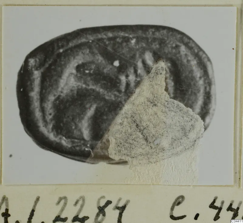 Oval seal or gem of dark stone with an engraved design, A.I.2284, mounted on a card