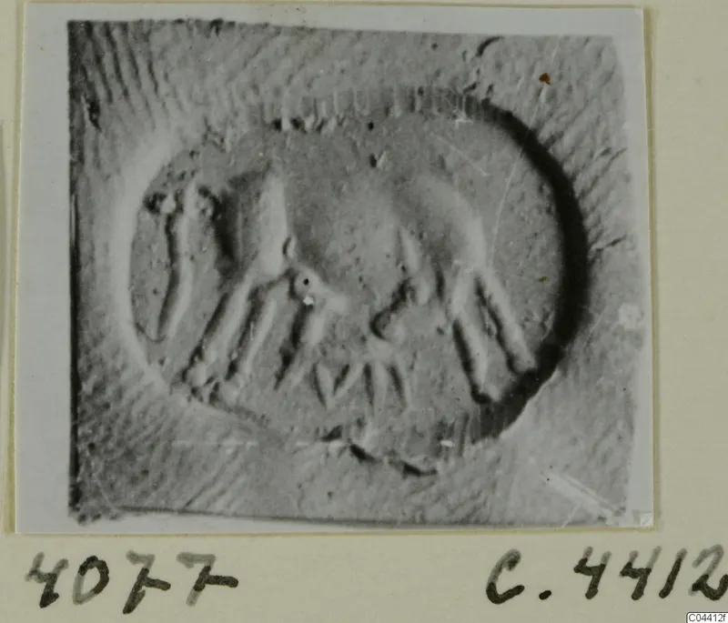 Seal impression from Ayia Irini with an oval design of raised motifs and a dark crescent along one edge
