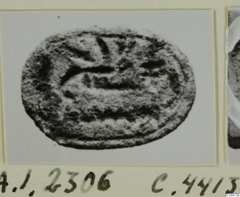 Oval engraved seal or gem with curved and straight incised lines, photographed on a mounted card