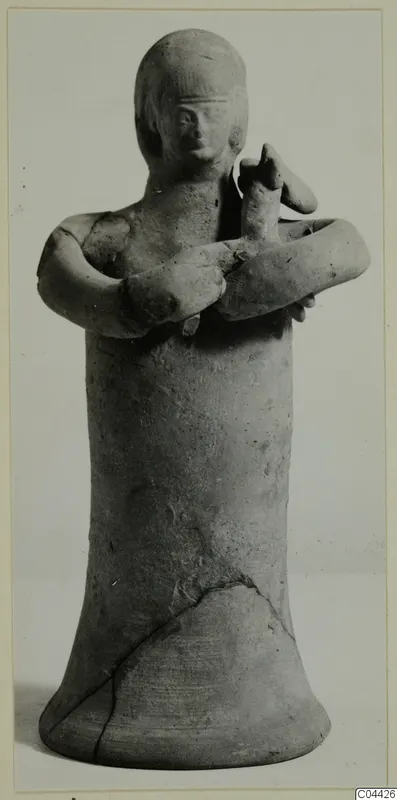 Terracotta statuette of a standing figure with arms crossed over the chest, shown from the front