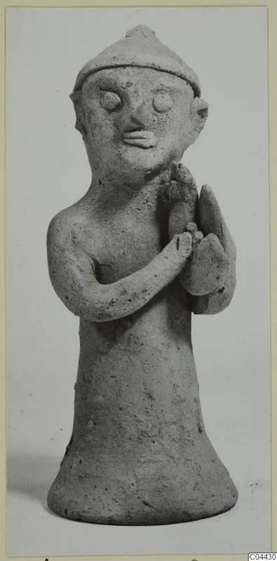 Terracotta figurine of a standing figure with a pointed cap and arms folded across the chest, from Ayia Irini