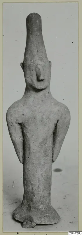 Terracotta figurine of a standing figure with a tall head and arms held at its sides