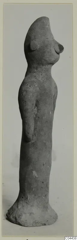 Terracotta figurine of a standing figure with a tall rounded head, narrow body and flared base