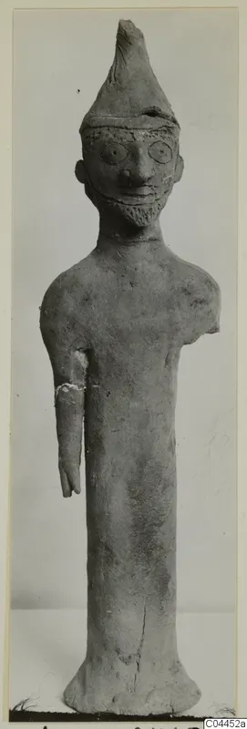 Terracotta figurine of a standing bearded figure in a tall pointed hat, from Ayia Irini