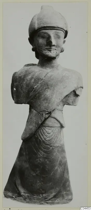 Terracotta statue of a bearded standing figure in a rounded cap, arms broken off, from Ayia Irini