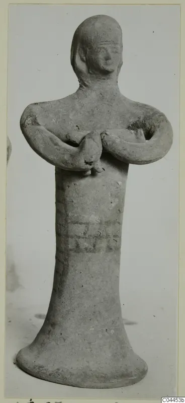 Terracotta figurine of a standing figure with arms bent and hands clasped at the chest