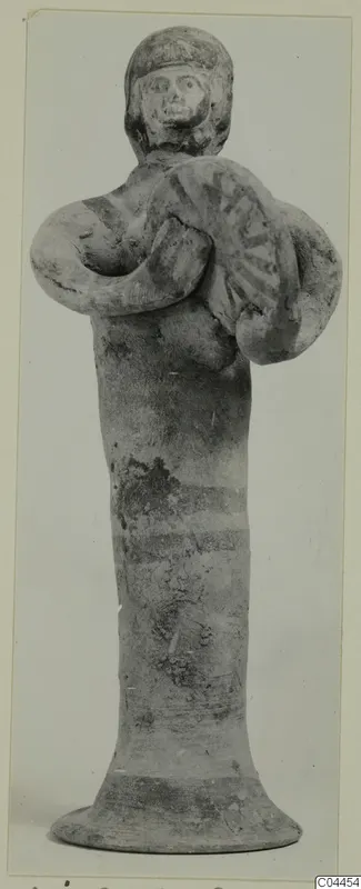 Terracotta figurine of a standing figure holding a round disc with radiating lines, from Ayia Irini.