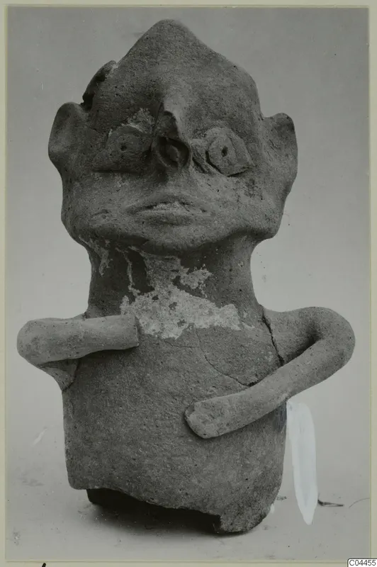 Terracotta figurine with a pointed head, modelled eyes and mouth, and two short arms, shown against a grey background.