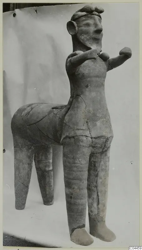 Terracotta figure of a standing human figure joined to a four-legged animal body, shown against a plain backdrop