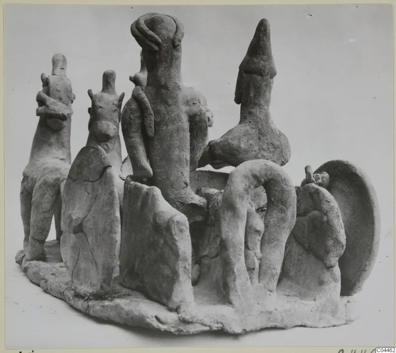 Terracotta group of several figurines on an irregular oval base, from Ayia Irini, photographed from a three-quarter angle