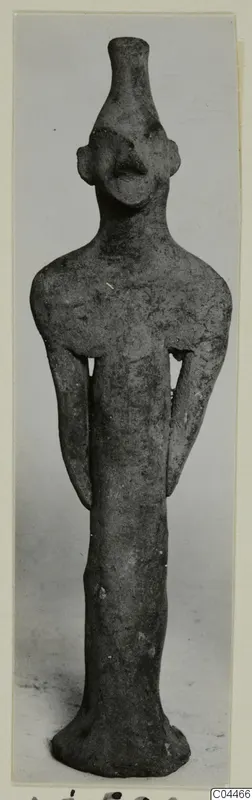 Terracotta figurine of a standing figure with a tall narrow neck, flat ears and arms held close to the body, from Ayia Irini