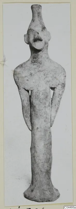 Terracotta figurine standing upright, with a long neck, small head and arms held close to the body