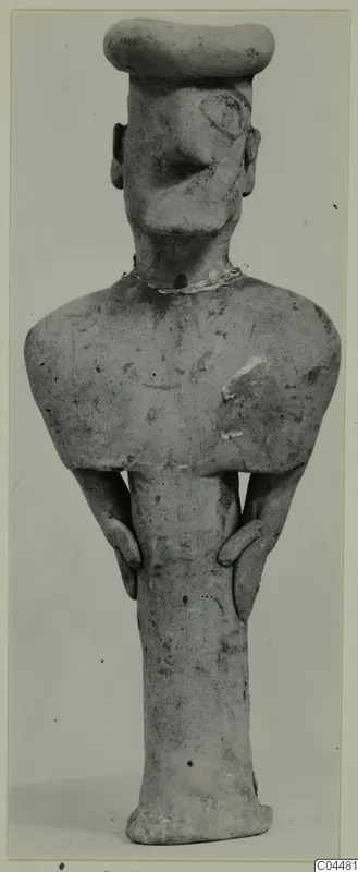 Terracotta figurine of a standing human figure with a flat-topped head and arms held at the sides.