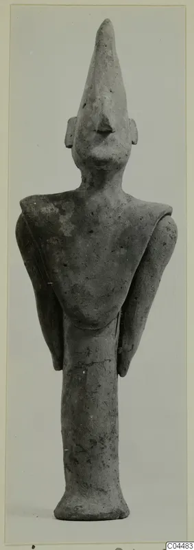 Terracotta figurine of a standing figure with a tall pointed headdress and arms held at its sides, from Ayia Irini