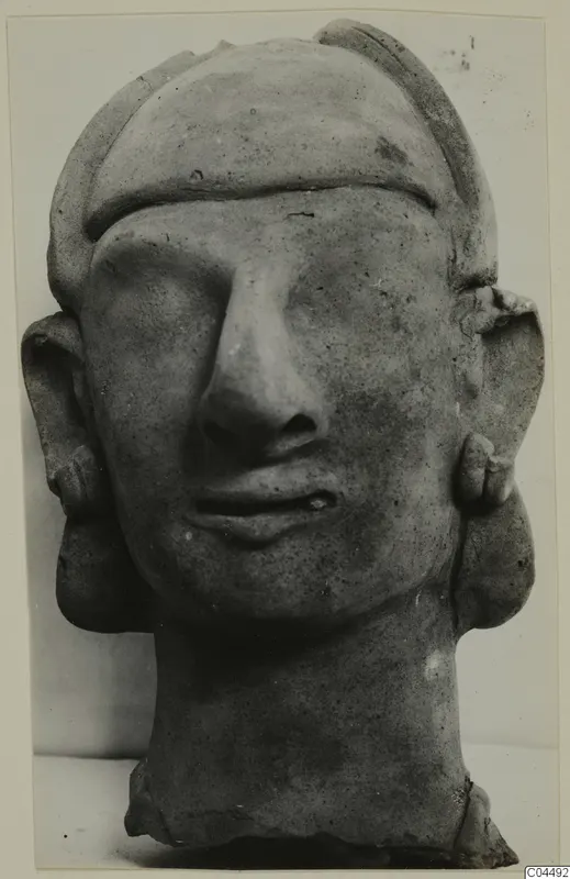 Terracotta head with a broad band across the forehead, a long straight nose and large flat ears with small ear ornaments
