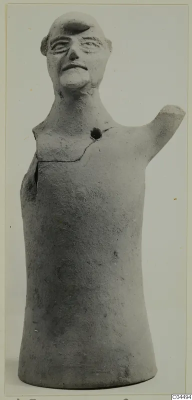 Terracotta figure of a human head and upper body with one arm raised, photographed against a pale background