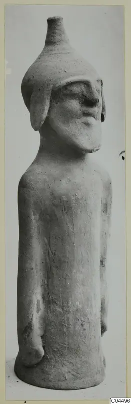 Terracotta figure of a standing human form with a tall conical head-top, from Ayia Irini
