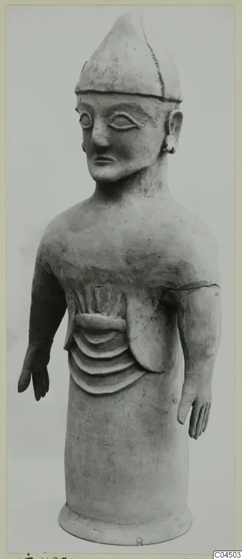 Terracotta standing figure with a pointed cap and arms held out from the body, from Ayia Irini