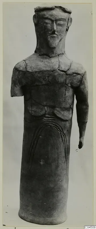 Terracotta standing figure from Ayia Irini with a cylindrical body and one arm broken off