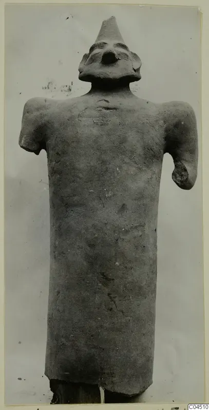 Terracotta figure with a tall conical top to the head and stubby arms, from Ayia Irini