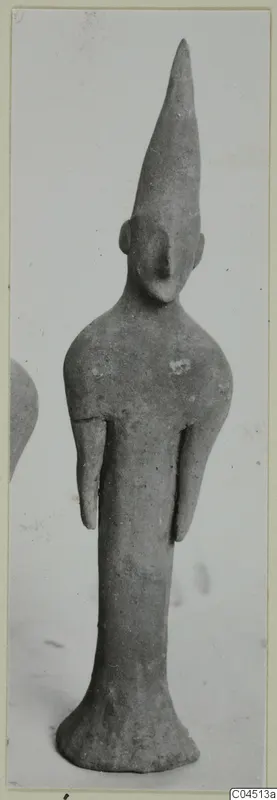 Terracotta figurine of a standing figure with a tall conical head and short stub arms