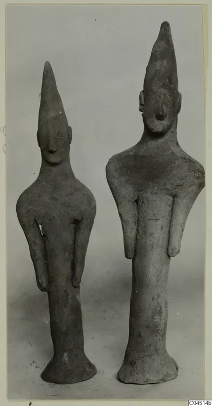 Two terracotta figurines with tall pointed heads and flared bases, standing side by side