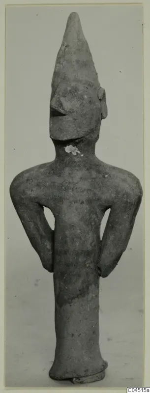 Terracotta figurine of a standing human figure with a tall pointed head and arms bent at the sides, from Ayia Irini