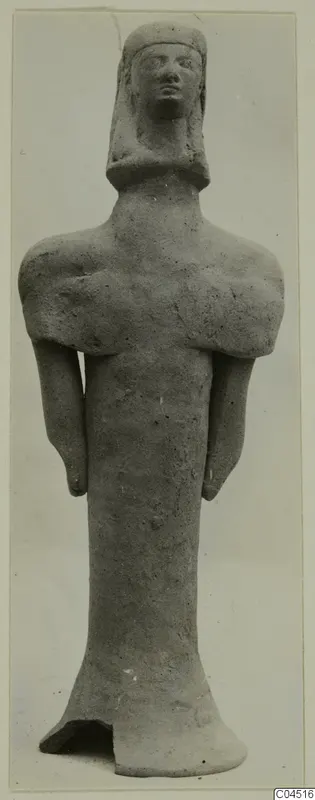 Terracotta standing figurine with arms at its sides and a broken base, photographed frontally against a plain grey background.