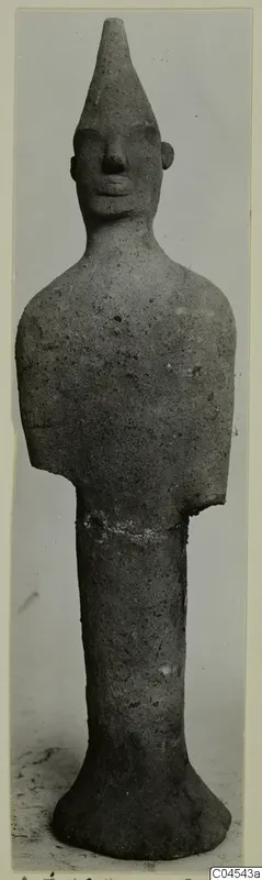 Terracotta figurine of a standing figure with a tall conical head and broken-off arms, from Ayia Irini