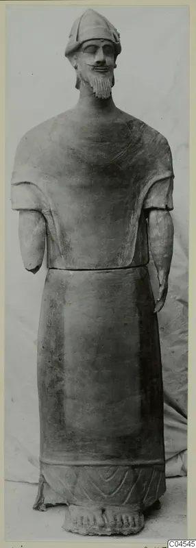 Terracotta statue of a bearded standing man in a close-fitting cap, forearms broken off, from Ayia Irini