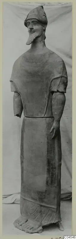 Terracotta statue of a standing bearded male figure in a long robe, shown full length