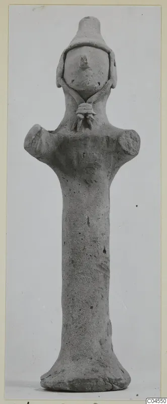 Terracotta figurine with a long cylindrical body, short projecting arms and a conical head, from Ayia Irini