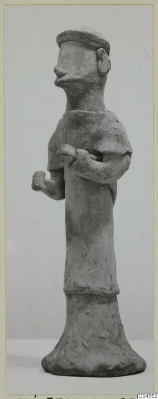 Standing terracotta figurine from Ayia Irini with bent arms and a flat-topped head