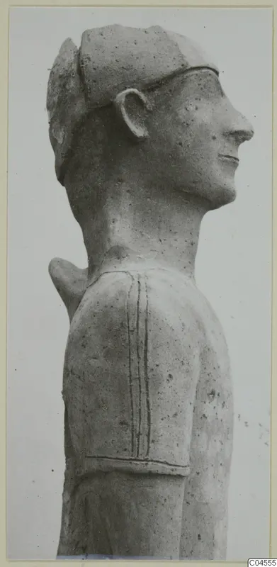 Terracotta statue of a figure's head and shoulder in side profile, with incised lines on the shoulder