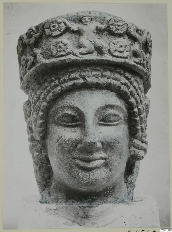 Limestone head with a tall decorated headdress and braided hair, from Arsos
