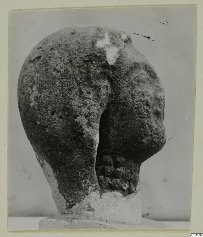 Limestone head from Arsos, shown from a side angle on a square base