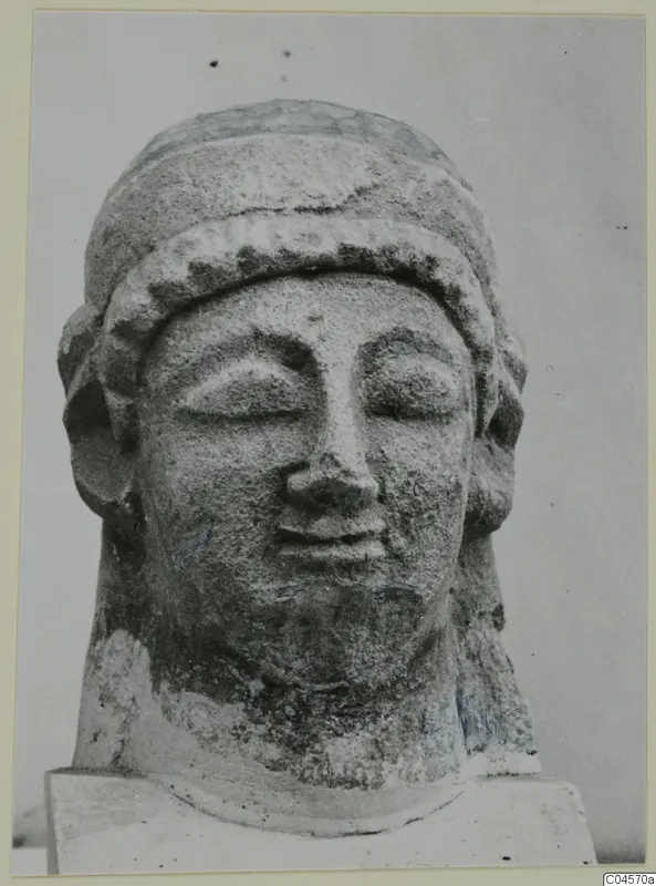Limestone head of a figure with closed eyes, a band across the forehead and hair at the sides.