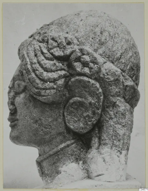 Limestone head of a statue from Arsos, shown in side profile with elaborate curled hair and a large ear ornament.