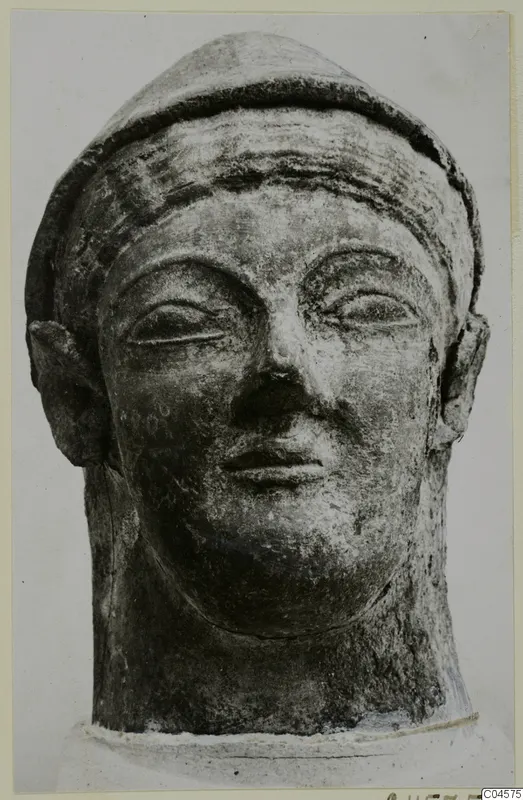 Head sculpture from Mersinaki with a close-fitting cap, wide ears, narrow eyes and a closed mouth
