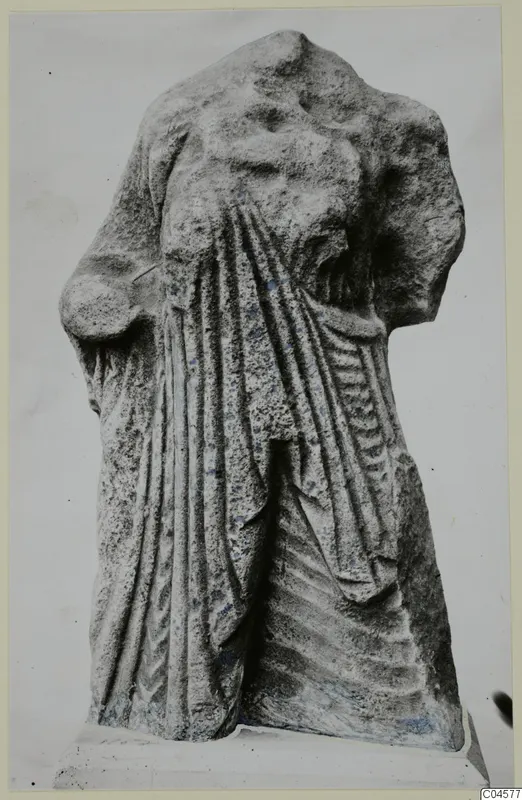 Limestone statue fragment from Arsos, headless and armless, with drapery folds, standing on a plinth.