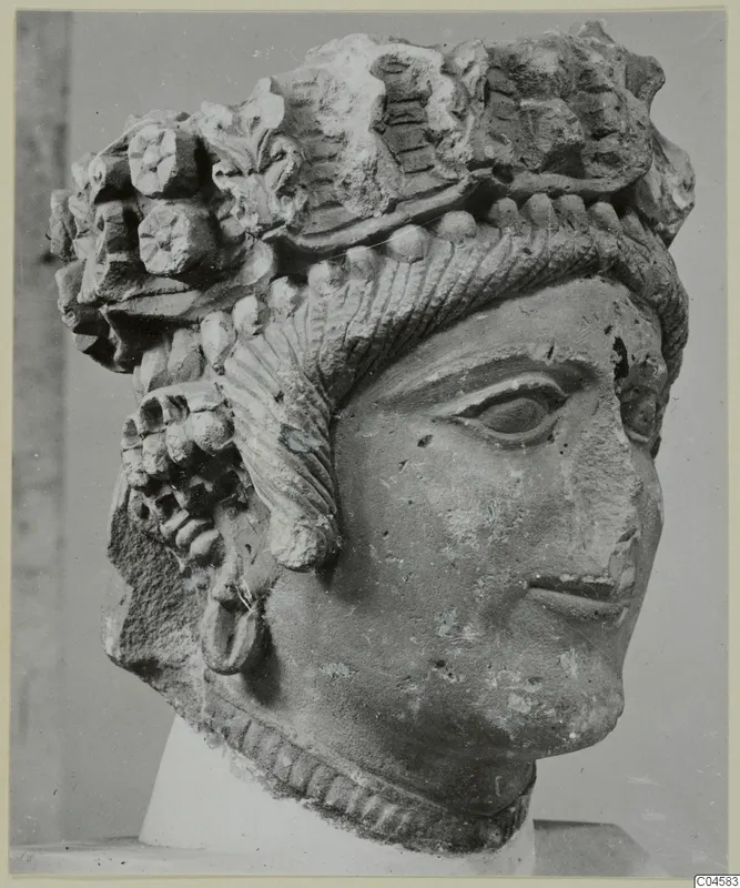 Carved limestone head from Arsos, with a high headdress of rosettes, leaf forms and ridged bands