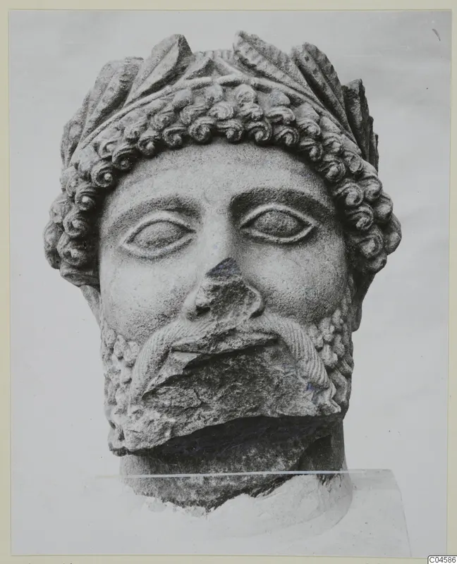 Limestone head of a bearded figure from Arsos, with curled hair, a broken nose and a chipped beard